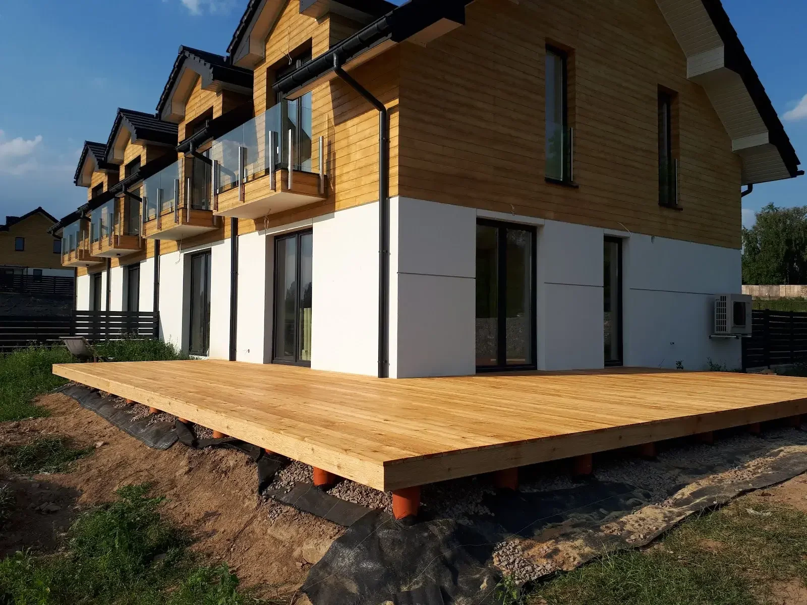 Casa con revestimiento de madera y fachada moderna de madera y obra